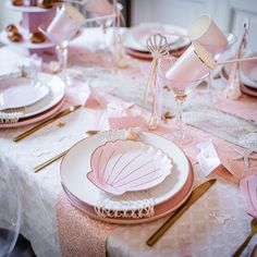 a table set with pink and white dishes