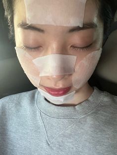 a woman with tape on her face and nose