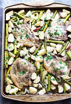 chicken, asparagus and potatoes in a roasting pan with parsley on top