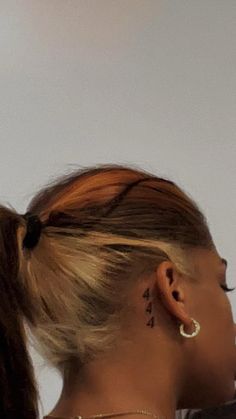 a woman with a tattoo on her left side of her neck and behind her ear