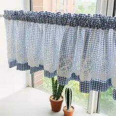 a potted cactus sitting on top of a window sill next to a curtain