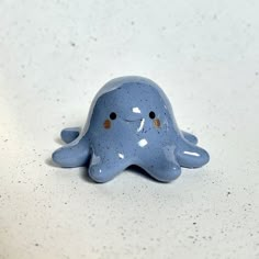 a blue ceramic figurine sitting on top of a white counter with speckles