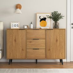 a living room with a wooden cabinet and pictures on the wall