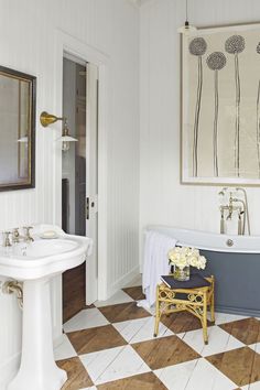 a bathroom with a checkered floor and an old fashioned bathtub in the corner