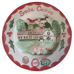 a plate with santa cookies painted on it