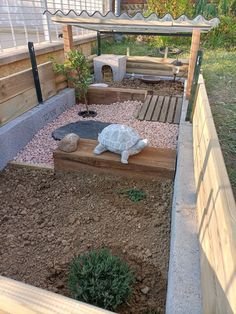 a small garden with rocks and gravel in the middle, including a turtle statue on top