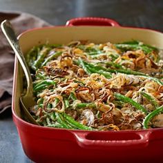 a red casserole dish filled with green beans and mushrooms