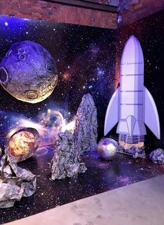 an image of a space themed room with rockets and planets on the wall in front of it