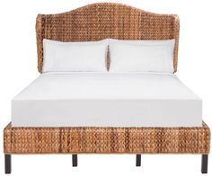 a wicker bed with white sheets and pillows