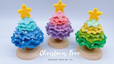 three small crocheted christmas trees on wooden bases