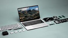 an open laptop computer sitting on top of a table next to other electronic components and accessories