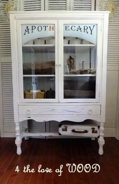 a white china cabinet with the words apotheary on it