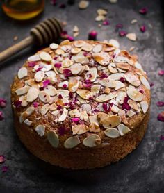 a cake topped with almonds and radishes on top of a black table