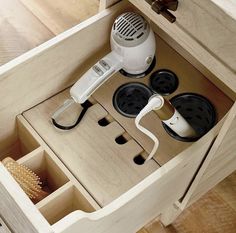 an electric hair dryer is sitting in a drawer with other items on the drawers