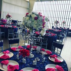 the table is set with blue linens and pink napkins