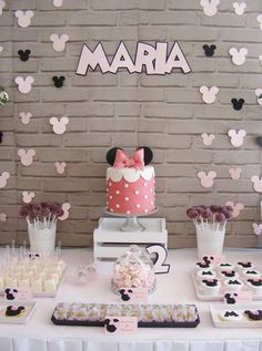 a minnie mouse cake and cupcakes on a table