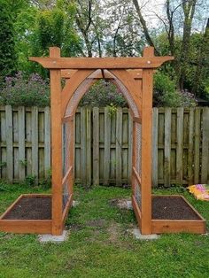 a wooden arbor in the middle of a yard