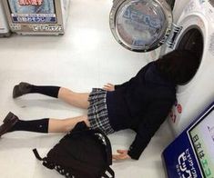 a woman laying on the floor next to a pile of clothes