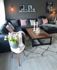 a living room filled with furniture and pictures hanging on the wall above it's coffee table