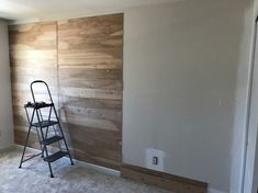 a ladder is standing in front of a wall with wood paneling on the walls