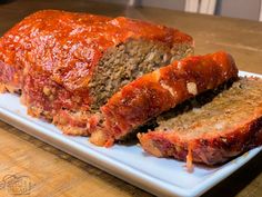 sliced meatloaf on a white plate with ketchup toppings and sauce