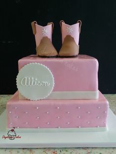 a pink cake with two pairs of shoes on top