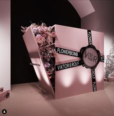 a pink display case with flowers in it and a watch on the front that says flowerbomb