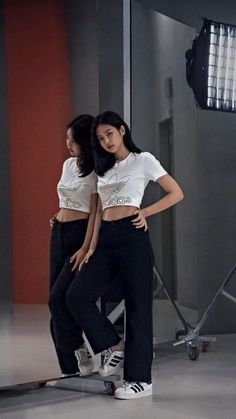 two young women are standing on skateboards in front of a camera set up for a photo shoot