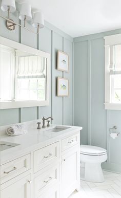 a bathroom with blue walls and white fixtures