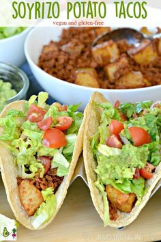 two tacos with lettuce, tomatoes and other toppings