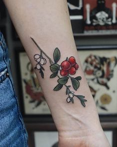 a woman's arm with a small flower tattoo on the left side of her wrist