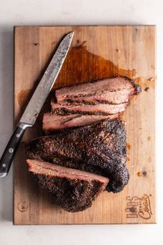 the steak is sliced and ready to be served on the cutting board with a knife