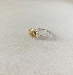 This one of a kind sundial ring is entirely handcrafted with 14k solid gold and sterling silver.  While it will most certainly not going to tell you the time, it is a reminder that the Sun is always shining even through the clouds. DETAILS: Sun: 6mm Silver dial plate: 10mm Band: 1.6mm Size 7 Hallmarked 14k and .925 Handmade Sterling Silver Stackable Rings In Yellow Gold, Handmade Gold Stackable Rings In Sterling Silver, Sun Design Jewelry Promise Ring, Silver Dainty Brass Rings, Dainty Silver Brass Rings, Sterling Silver Jewelry With Sun Design In Yellow Gold, Silver Brass Rings Fine Jewelry, Sterling Silver Flower Ring In Yellow Gold, Sun Design Ring Jewelry Gift