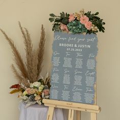 a wooden easer with a seating sign and flowers on the table next to it