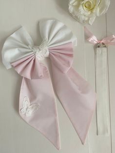 two pieces of pink and white clothing with bows