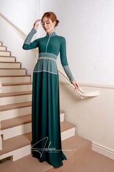 This exquisite ao dai is expertly designed with a traditional collar and floor-length silhouette, showcasing its rich moss green hue. Crafted from luxurious fabric, it also comes with a pair of black pants, making it perfect for any formal occasion. Let this timeless piece elevate your wardrobe with its elegant and sophisticated appeal. Luxurious Fabric, Ao Dai, Green Bead, Moss Green, Blue Beads, Luxury Fabrics, Formal Occasion, Timeless Pieces, Floor Length