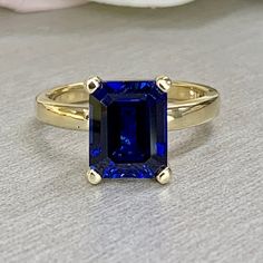 Emerald cut blue sapphire engagement ring yellow gold, Blue sapphire solitaire ring, September birthstone jewelry, Blue sapphire ring, #6132 #LabCreatedSapphire #PromiseRing #BirthdayGift #EmeraldCut #DiamondRing #WeddingRing #AnniversaryRing #BirthstoneRing #AnniversaryGift #EngagementRing Sapphire Ring With Radiant Diamond Cut, Radiant Cut Sapphire Ring With Diamond Cut, Blue Sapphire Ring With Radiant Diamond Cut, Blue Sapphire Ring With Radiant Cut, Blue Sapphire Ring In 14k Gold For Promise, Blue Sapphire Promise Ring In 14k Gold, 14k Gold Radiant Cut Sapphire Promise Ring, Diamond-cut Sapphire Promise Ring, Diamond Cut Sapphire Ring For Promise