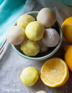 some lemons are sitting in a bowl next to two lemons