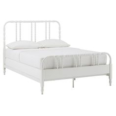 a white bed with an iron frame and headboard is shown in this image, it has