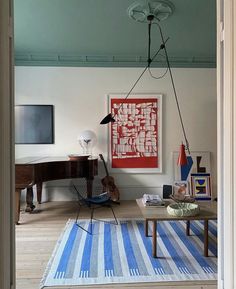 a living room filled with furniture and a painting hanging on the wall over a table