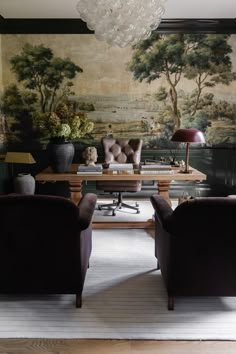 two chairs and a table in front of a painting