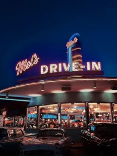 a drive - in with cars parked outside at night