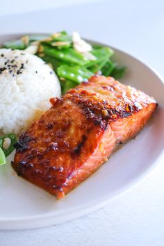 a white plate topped with salmon, rice and broccoli