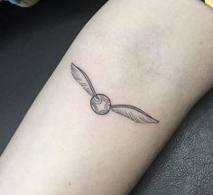 a black and white photo of a bird tattoo on the left arm, with an eyeball in the middle