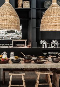 two large baskets hanging from the ceiling above a table with food in bowls on it