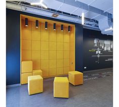 an empty room with several yellow chairs and stools