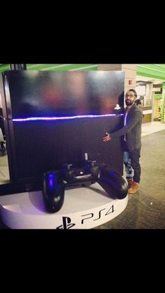 a man standing next to a large monitor