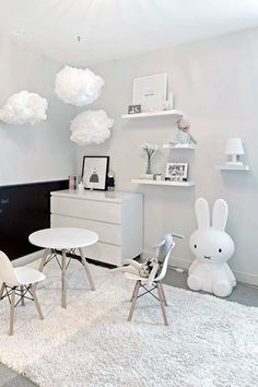 a room with white furniture and decorations on the walls, carpeted flooring and rugs