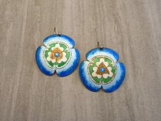 "These vintage 1970s cloisonné enamel pierced earrings feature a large flower, or Kamon Japanese Family Crest, in sterling silver 24k gold wash. The enamel colors are Sapphire, Light Sapphire, Chalk White, Emerald and Light Smoked Topaz. The earrings measure approximately 1-1/2\" in length, 1-1/4\" in width, with a 1-1/4\" drop, and are marked SILVER. They were handmade by Chinese artisans. This pair is similar to those from Laurel Burch's 1970s \"Stone Collection,\" and similar to Laurel Burch, Vintage Enamel Flower Earrings, Handmade Enamel Flower Shaped Earrings, Vintage Hand Painted Enamel Earrings, Vintage Hand-painted Enamel Earrings, Japanese Kamon, Japanese Family Crest, Flower Japanese, Light Sapphire, Laurel Burch