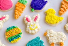 some decorated cookies are sitting on a white counter top with colorful icing around them